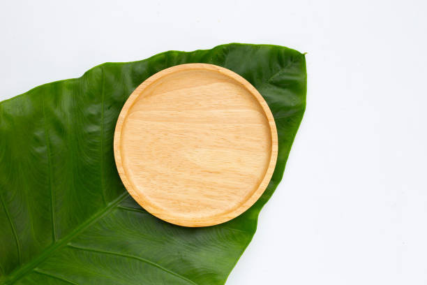 istock Wooden plate on green leaves 1408350395