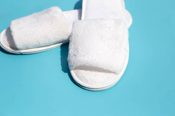 istock Hotel slippers on blue background. Copy space 1408352219