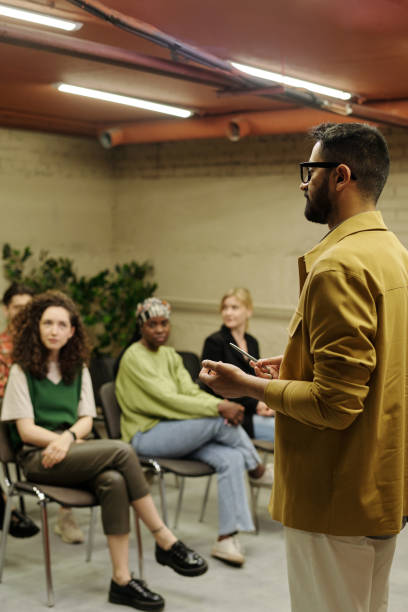 istock Confident business coach standing in front of audience during presentation 1408354601