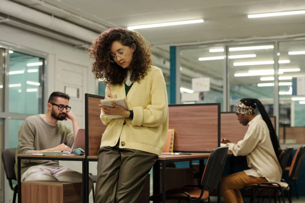 istock Young businesswoman making working notes or writing down points of plan 1408354667