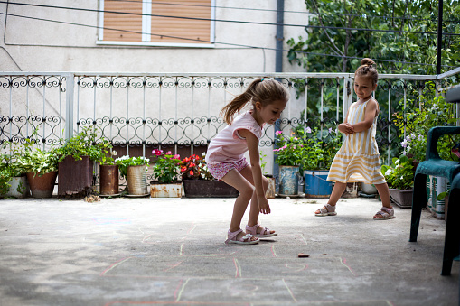 girls playing hopscotch outdoors