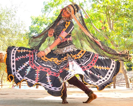 This was shot in Udaipur, Rajasthan, India on October 26, 2017. A beautiful and young woman dancer in traditional Rajasthani costume looks at the camera during a dance performance.
