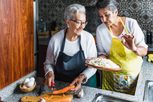 mujeres hispanas abuela e hija cocinando en casa cocina en méxico latinoamérica - old culture fotografías e imágenes de stock