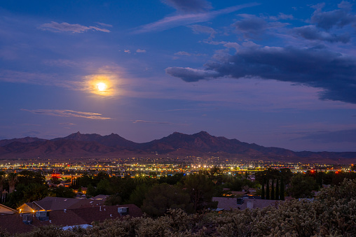The moon rises over the city of Kingman, Arizona, which is located along historic Route 66. The Hualapai Mountains are in the background.