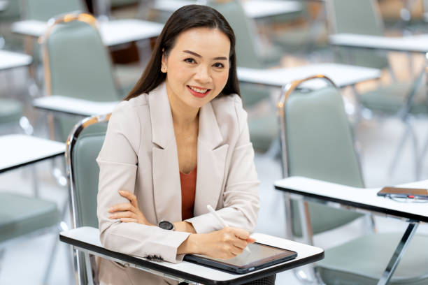 istock asia woman Teacher taking notes from tablet at library at university 1408364743
