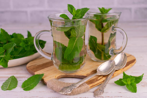 istock Mint tea in transparent cups on a wooden board. 1408364966