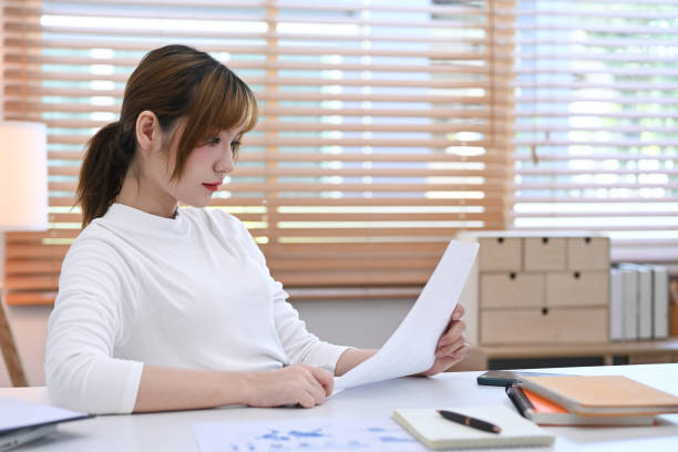 istock Concentrated young investor is reading statistics document, planning business strategy at home office. 1408365850