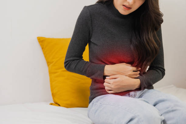 istock Young woman suffering from strong abdominal pain while sitting on bed at home 1408368948