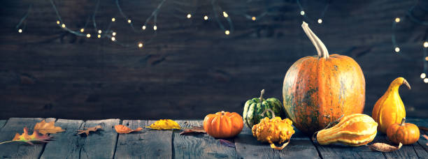 istock Autumn frame with pumpkins on wooden table and orange leaves 1408369082