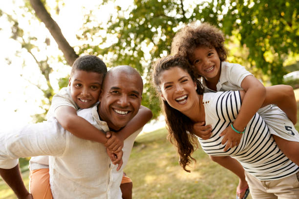 Parents piggybacking their sons in the park