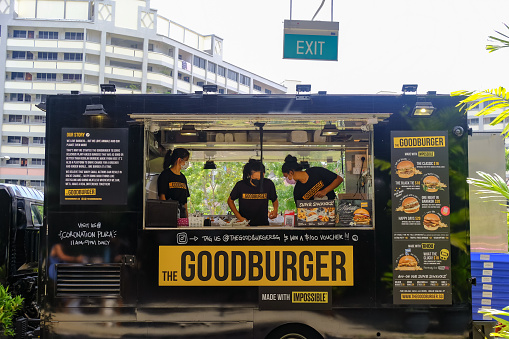 Singapore 2022Mar Staff preparing burgers and fries in a food truck at an event at Sunday Social Market. Food trucks are starting to gain popularity here
