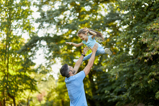 Father and daughter having fun playing together in the park