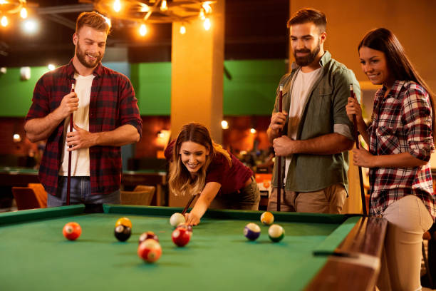 istock Group of friends having fun while playing pool in a local pool hall 1408369937