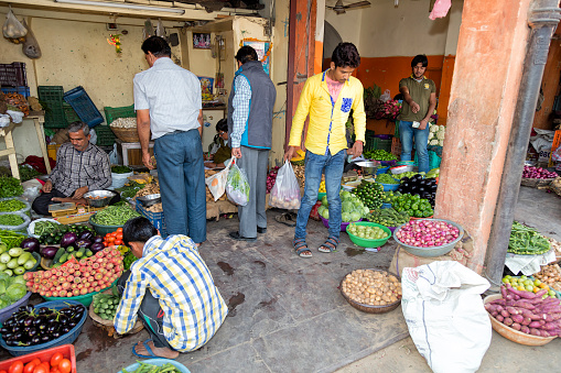 Jaipur, India - January 7, 2020: Men buying vegetables on the street in Jaipur, Rajasthan, India. Jaipur is the capital and largest city of the Indian state of Rajasthan in Northern India.