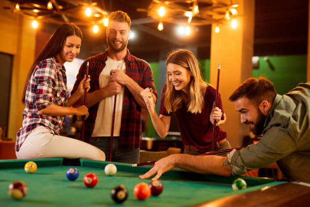 istock Group of friends having fun while playing pool in a local pool hall 1408370343