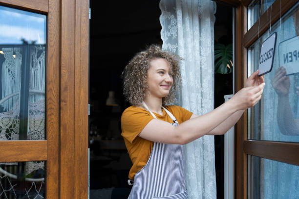 istock Caucasian waitress changing sign on cafe doors 1408371233
