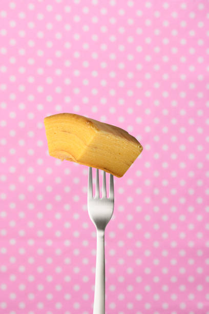 Fork and a slice of baumkuchen against a pink polka-dot tablecloth