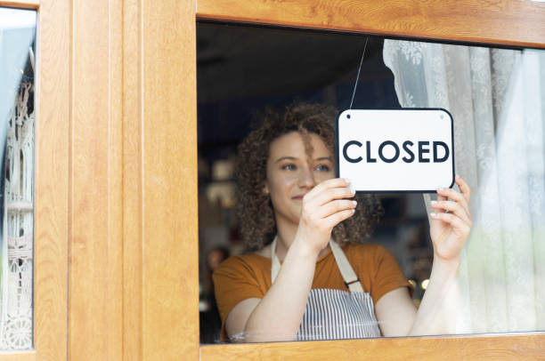 istock Caucasian waitress changing sign on cafe doors 1408371262