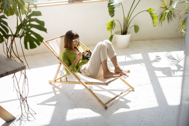 istock Woman sits relaxed with a drink in room with plants 1408371950
