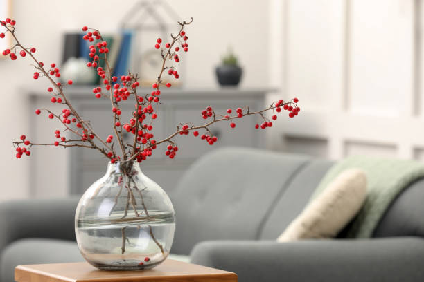 istock Hawthorn branches with red berries on wooden table in living room, space for text 1408371982