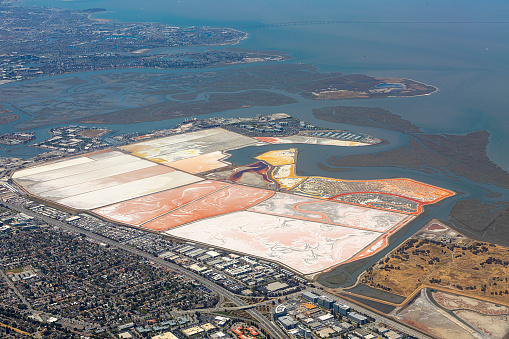 aerial of Newark marshland at the coast with canal and saltern fields to stabilize ground, Newark, San Francisco, USA