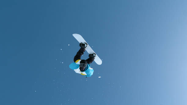 istock Fearless male snowboarder does a backflip after jumping off a massive kicker. 1408372790