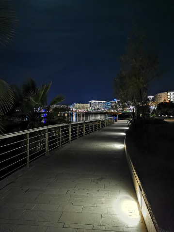 Night Protaras. View of the illuminated promenade with railings, running along the seashore against the backdrop of a black sky
