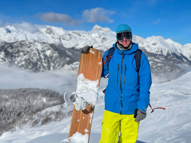 istock PORTRAIT: Cheerful male snowboarder smiles for camera before riding off-piste 1408372941