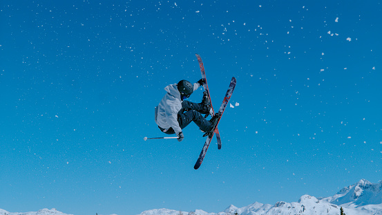 A pair of fast skiers rocket down a groomed trail on Ajax Mountain at Aspen Colorado.