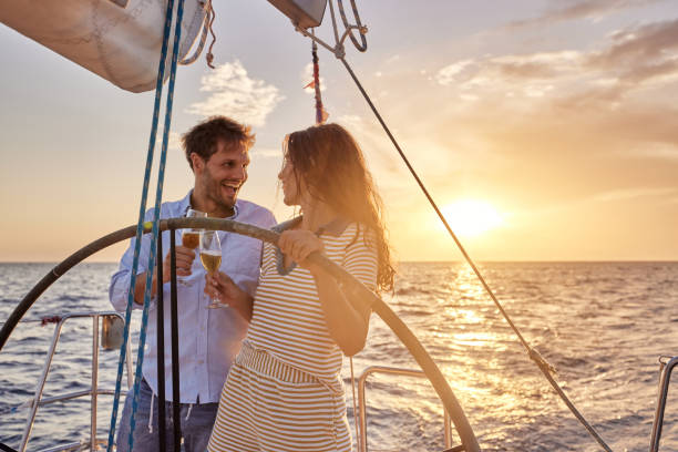 istock Happy couple toasting while driving a yacht at sunset. 1408373279