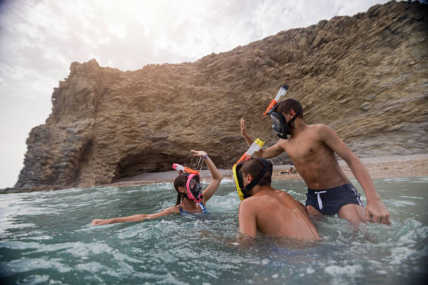 istock Kids enjoying snorkeling on rocky beach 1408374049
