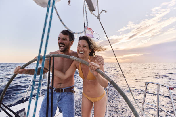 istock Cheerful couple having fun while driving a boat at sea. 1408374209