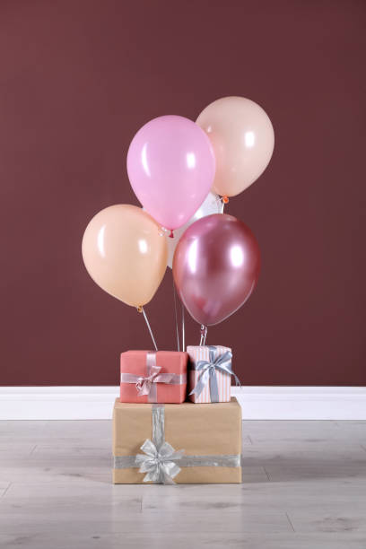 istock Many gift boxes and balloons near brown wall 1408374217