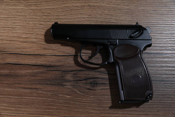 istock Handgun on wooden table, top view. Semi-automatic pistol 1408375448