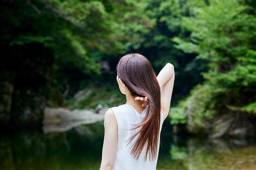 A woman who brushes her hair in a lush nature