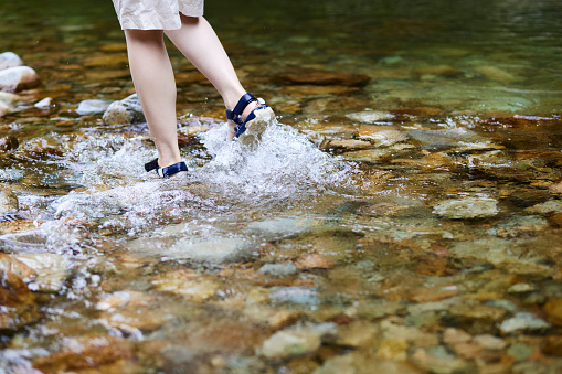 The feet of a young woman immersed in the river