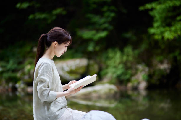 istock Japanese woman reading in nature 1408376852