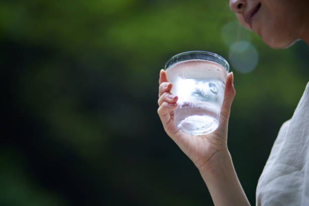 自然の中でコップに水を入れた女性 - refreshing drink ストックフォトと画像