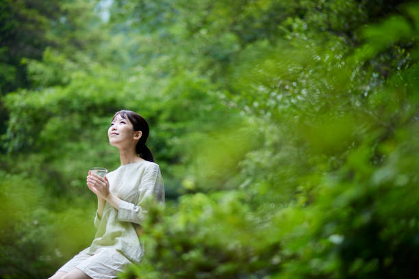 istock Woman with water in a cup in nature 1408377392