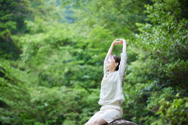 หญิงสาวชาวญี่ปุ่นที่ทอดยาวออกไปในธรรมชาติ - forest bathing ภาพสต็อก ภาพถ่ายและรูปภาพปลอดค่าลิขสิทธิ์