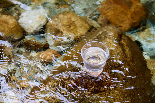 istock Glass with water placed in a beautiful river 1408377476