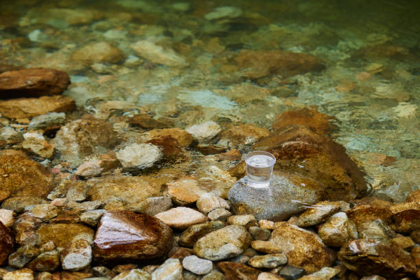Glass with water placed in a beautiful river