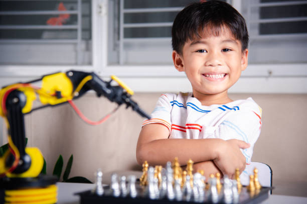 istock Asian little boy is playing chess with robot machine arm 1408377496
