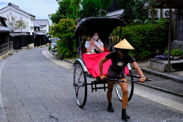 Rickshaw driver and passenger wearing masks in Arashiyama stock photo
