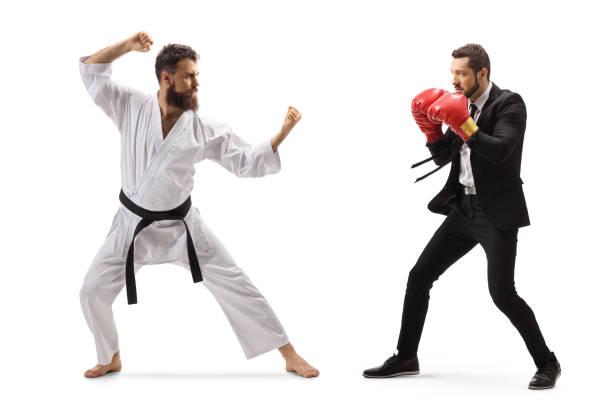 foto de perfil completo de un hombre de negocios con guantes de boxeo peleando con un hombre en kimono de karate - boxing caucasian men business fotografías e imágenes de stock