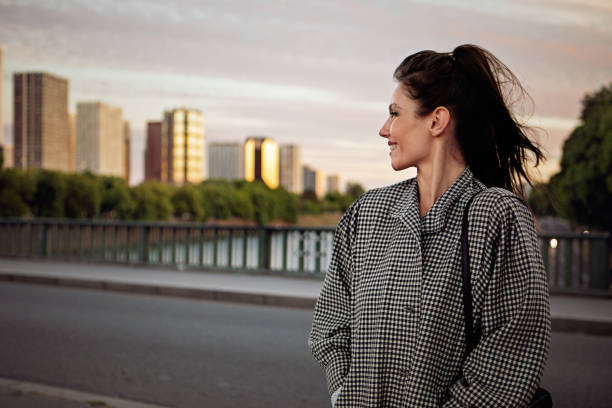 Young woman is looking sunset over the city