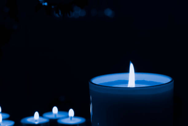 luxury blue lighting aromatic scent candle to create romantic and relax with dark background. Idea as Cozy home interior decor, burning candles.