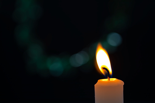 A candle light set against dake defocus background.