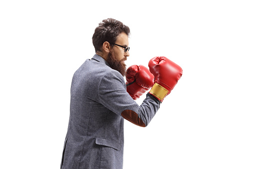 Profile shot of a casual man boxing with boxing gloves isolated on white background