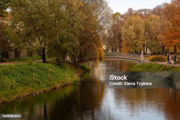 A Beautiful Bridge Over The River In The City Park On An Autumn Day Autumn In The City Park Yellow And Red Trees On The Bank Of The River Stock Photo - Download Image Now